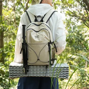 Vue arrière d'un sac à dos de randonnée léger avec bâton de marche et tapis de sol