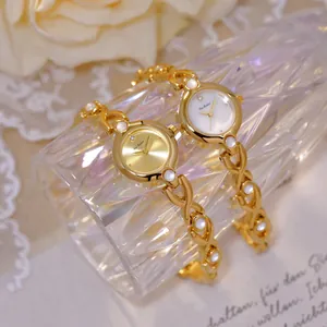 Primer plano de relojes vintage Bee Sister dorados con correas de cadena entrelazadas