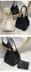 Elegant detail view of a black and beige woven bucket bag set with a matching small pouch