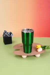 Vibrant green 30oz stainless steel vacuum insulated tumbler on a creative wooden stand