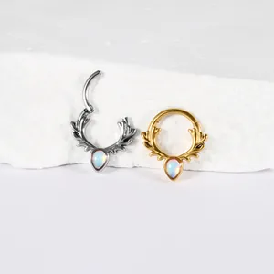 Detail of stainless steel antler septum rings with teardrop opal stones in silver and gold.