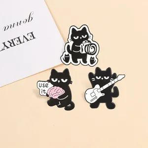 Set of three black cat enamel pins featuring guitar, camera, and brain 'Use it' designs