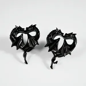 Nahaufnahme von schwarz beschichteten Drachenherz-Ohrstretching-Plugs aus Stahl