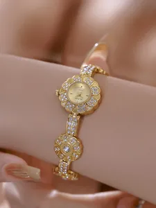 Close-up view of the golden flower-shaped bracelet watch decorated with shimmering crystals