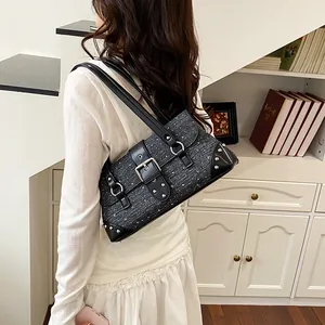 Close-up view of a stylish grey denim baguette shoulder bag with silver buckle