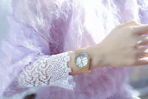 Vista detallada de un reloj tonneau de lujo dorado con elegantes detalles de pedrería