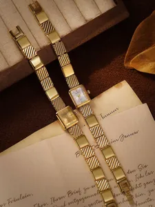 Primer plano elegante de relojes dorados vintage sobre cartas retro escritas a mano