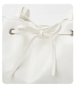 Detailansicht einer weißen Ledertasche mit stilvollem Schleifen-Kordelzug-Design