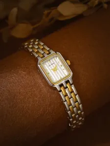 Detaillierte Nahaufnahme einer rechteckigen Vintage-Uhr mit zweifarbigem Edelstahlband