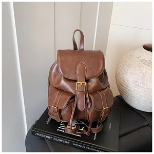 Primer plano de mochila vintage de cuero marrón con bolsillos de hebilla y textura