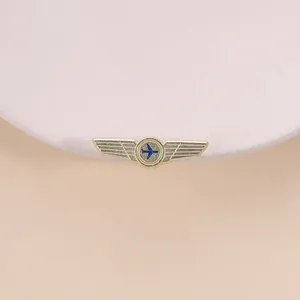 Detaillierte Ansicht der goldenen Retro-Pilot-Flügel-Brosche mit blauem Flugzeug.