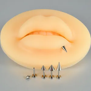 Close-up of G23 titanium internal thread spike labret piercings on a silicone lip model