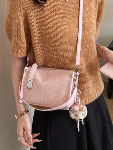 Elegant pink textured pillow bag featuring a cute plush dog keychain for women