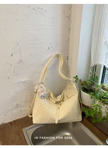 Detail of cream polka dot tote bag with cute bunny keychain in a lifestyle setting