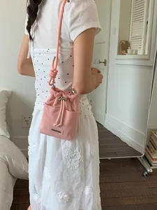 Elegant pink canvas bucket crossbody bag for women with drawstring closure and strap