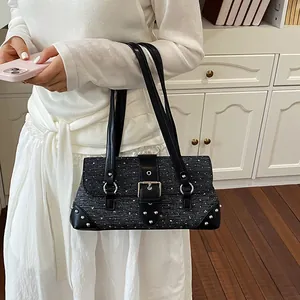 Detailed close-up of a black tweed baguette bag featuring silver rivets and buckle detail