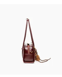 Detailed side view of a vintage burgundy leather shoulder bag with dual long straps for women