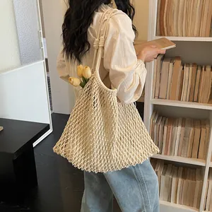 Borsa a spalla in rete intrecciata francese con tulipani in un'accogliente biblioteca