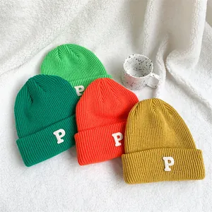 A set of vibrant ribbed knit beanies with embroidered P patch on white texture