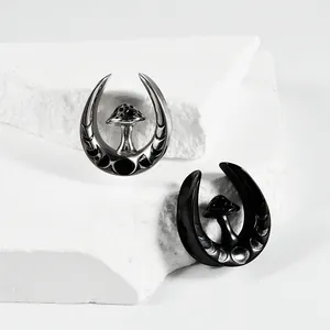 Detailed view of U-shaped stainless steel ear gauges with mushroom design in silver and black