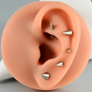 Close-up of G23 titanium spike ear studs on a silicone ear model for piercing display.
