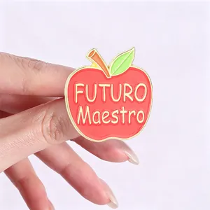 Detail of red apple enamel pin with "FUTURO Maestro" Spanish text for teachers