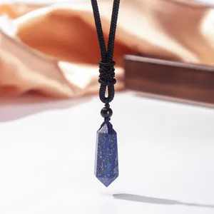Detailaufnahme eines hexagonalen Lapislazuli-Kristallanhängers an einer schwarzen Kordel.