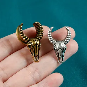 Vue détaillée de boucles d'oreilles tête de mouton vintage en bronze et argent sur fond bleu.