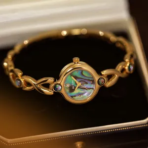 Primer plano detallado del reloj vintage dorado Bee Sister con esfera de nácar de abulón