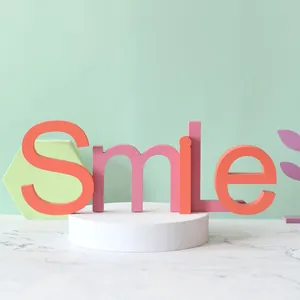 Lettres Smile en bois pastel sur un socle pour la décoration de chambres d'enfants
