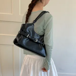 Lifestyle view of a black fashion underarm tote bag with stylish buckle detail and silver hardware