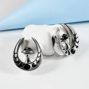 Detailed macro view of stainless steel U-shaped ear expanders with black mushroom design