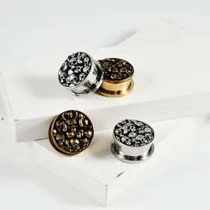 Vue détaillée des écarteurs d'oreilles tête de mort en finitions argent et bronze