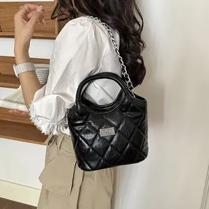 Elegant model carrying a high-quality black quilted bucket bag with a stylish chain strap