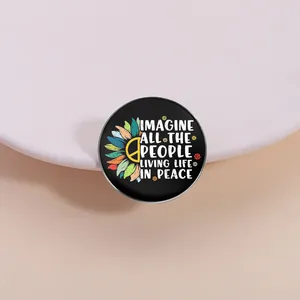 Close-up of peace theme sunflower brooch with 'Imagine' quote on a white stone.
