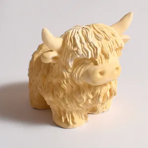 Detailed close-up of a cream-colored resin Highland cow figurine with realistic fur texture