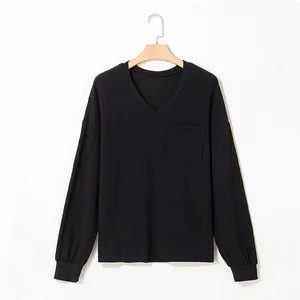 Close-up detail of a casual black V-neck long-sleeve sweatshirt with a chest pocket.