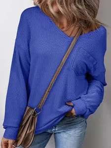 Close-up detail of women's blue waffle-knit V-neck sweatshirt showing fabric texture