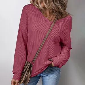 Close-up detail of a dark pink V-neck waffle knit pullover sweater with front pocket