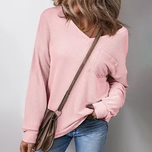 Close-up detail of women's pink waffle knit V-neck sweatshirt with pocket and long sleeves