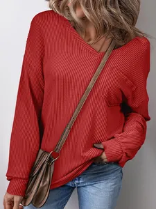 Close-up detail of women's casual red V-neck waffle knit pullover with front pocket detail