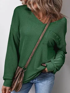 Close-up of women's dark green V-neck waffle knit sweatshirt with textured fabric detail