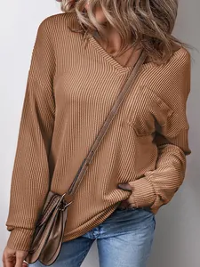 Close-up of women's waffle knit V-neck sweater showing pocket detail and texture.