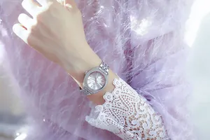 Primer plano de un reloj de lujo plateado para mujer con bisel y correa de cristal