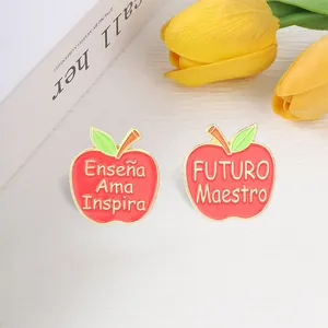 Close-up detail of red apple enamel pins featuring Spanish teacher appreciation quotes