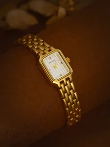 Nahaufnahme der goldenen rechteckigen Bee Sister Uhr mit elegantem gestreiftem Zifferblatt.