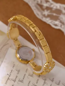 Detail view of gold floral bracelet watch band with crystal accents
