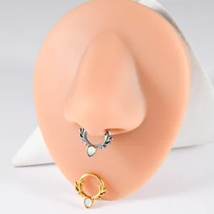 Detailed view of antler segment piercing rings on silicone nose model in silver and gold