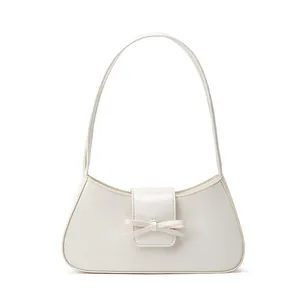 Elegante cremeweiße Schultertasche mit einer dekorativen Schleife auf der Klappe