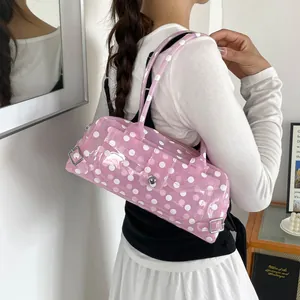 Pink polka dot PVC transparent baguette shoulder bag worn over the shoulder by a model